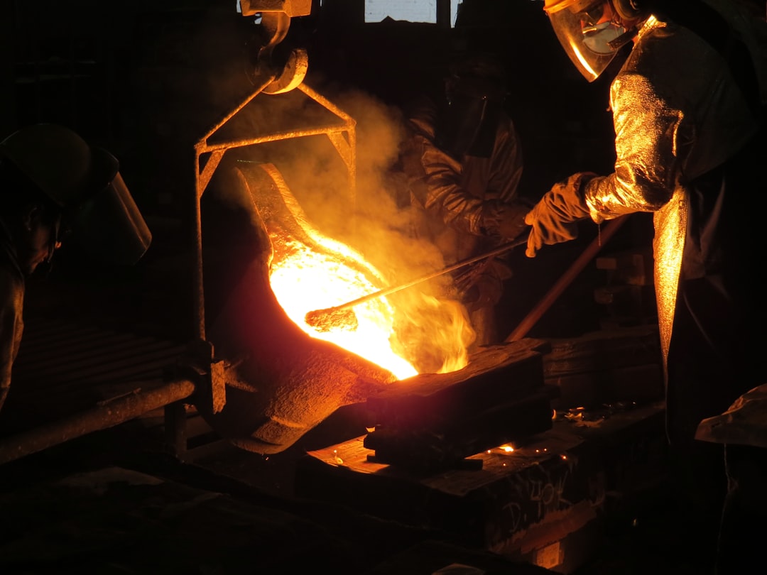 Artisan travaillant le fer à la forge, marteau et pince en main